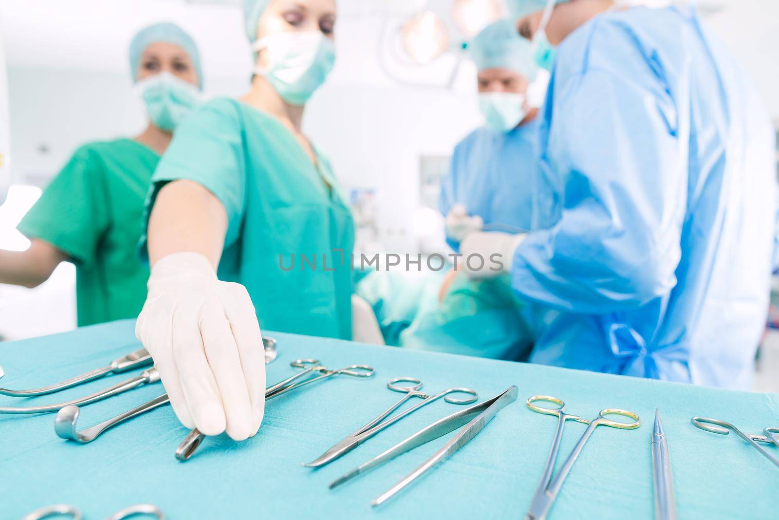 Surgeons operating patient in operating room by Kzenon