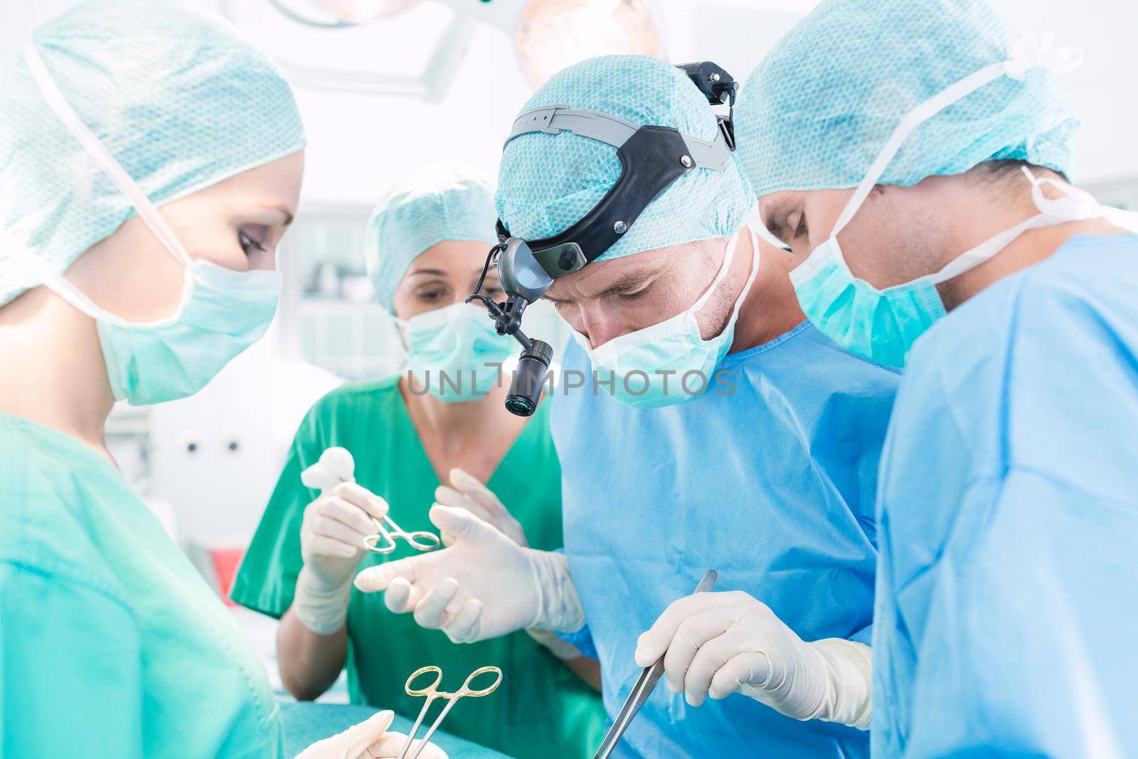 Surgeons operating patient in operation theater by Kzenon
