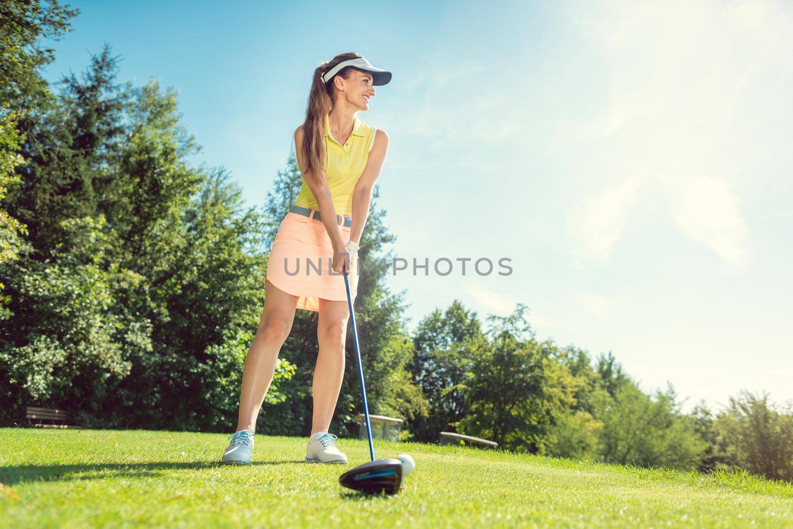 Beautiful woman on golf course at tee, low shot