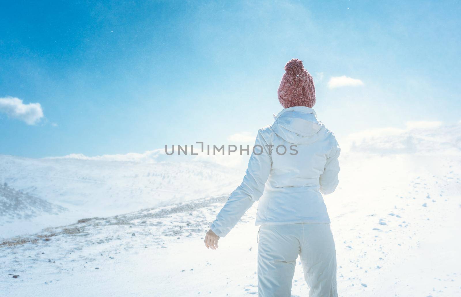 Woman looking at the first snow in the mountains seen from behind