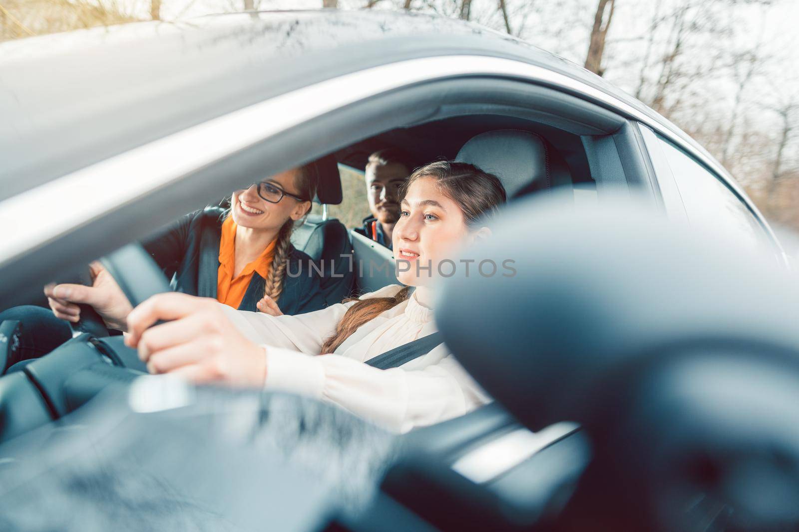 Student in driving school during the final test with instructor and examiner