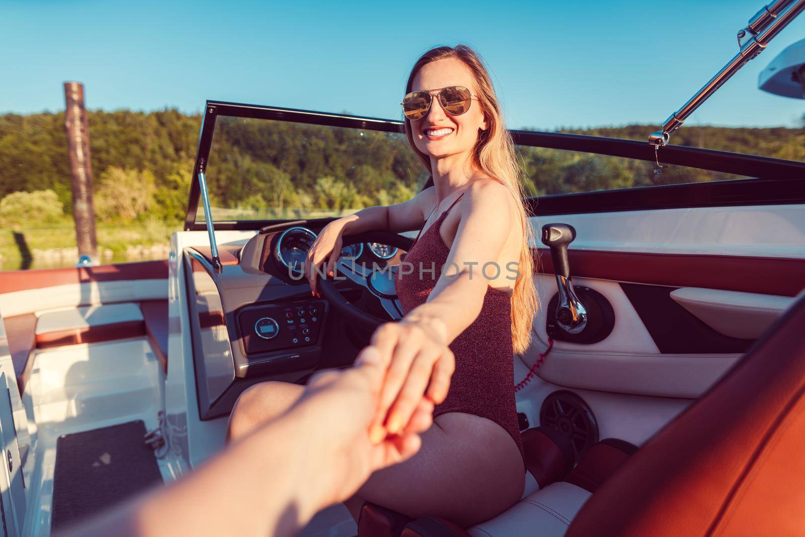 Woman inviting her friend to have a ride on the river yacht, pov shot