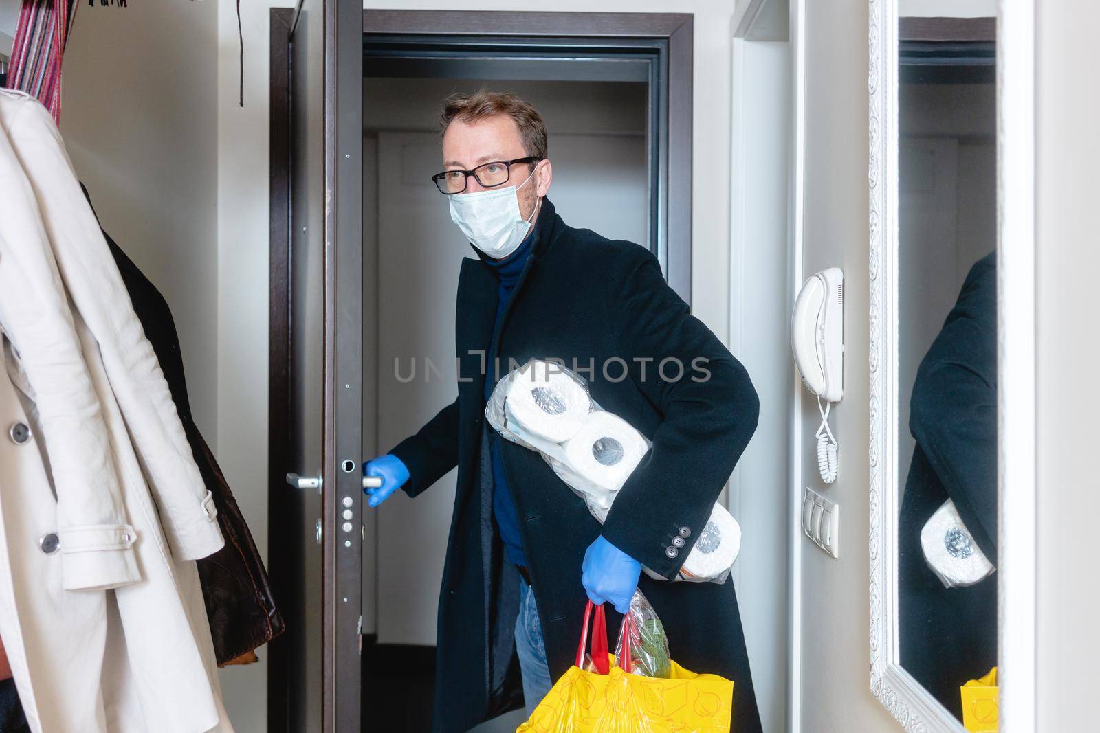 Man wearing medical mask coming home from shopping and hoarding with toilet paper