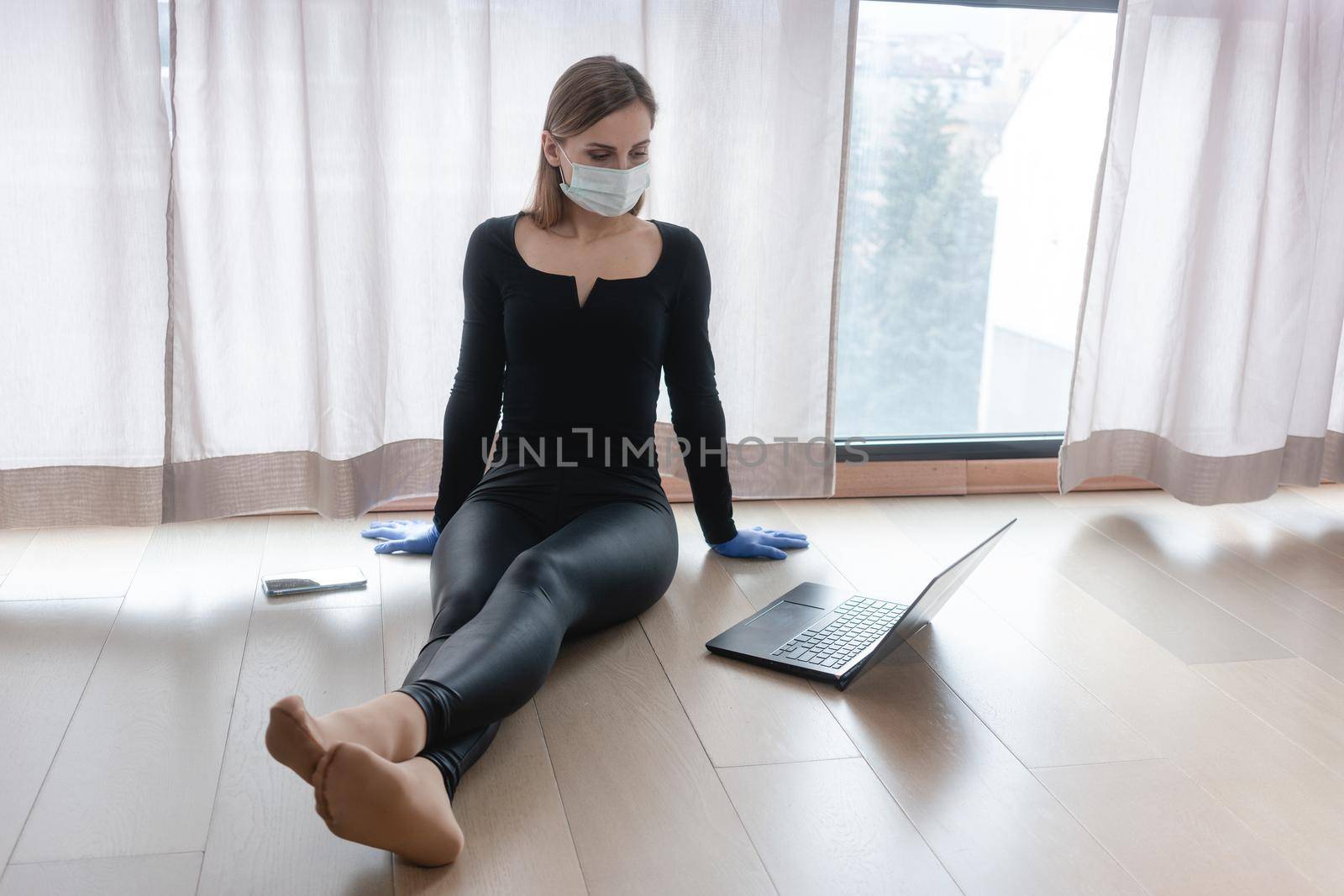 Woman in corona quarantine doing home office sitting by the window