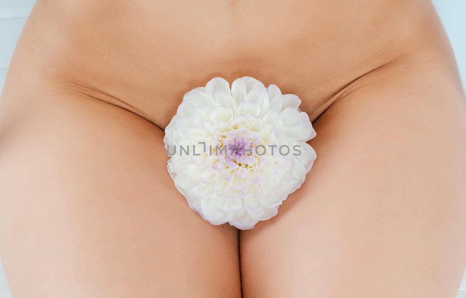 Concept picture for pubic hair removal, woman with flower