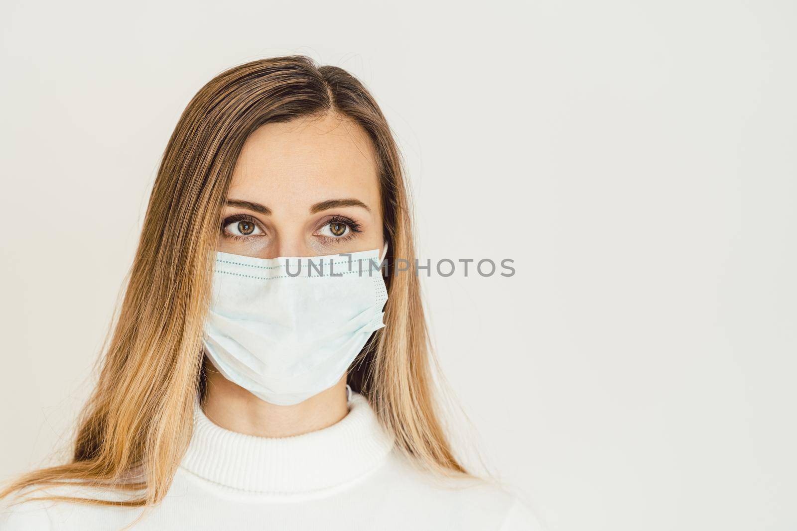 Anxious woman with face mask worried about the Covid-19 outbreak staying at home