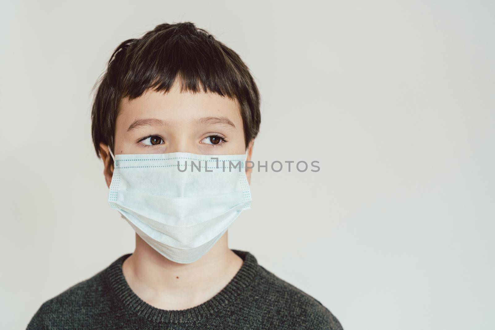 Young boy wearing face mask during Covid-19 crisis staying at home