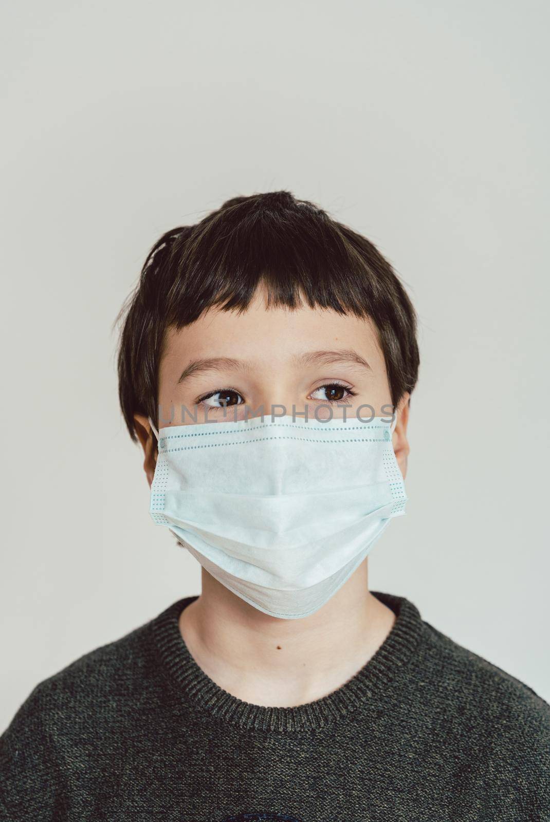 Young boy wearing fact mask during Covid-19 crisis by Kzenon
