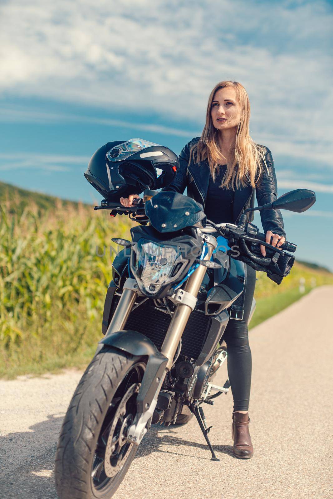 Beautiful woman on a motorcycle looking at the road ahead on summer day
