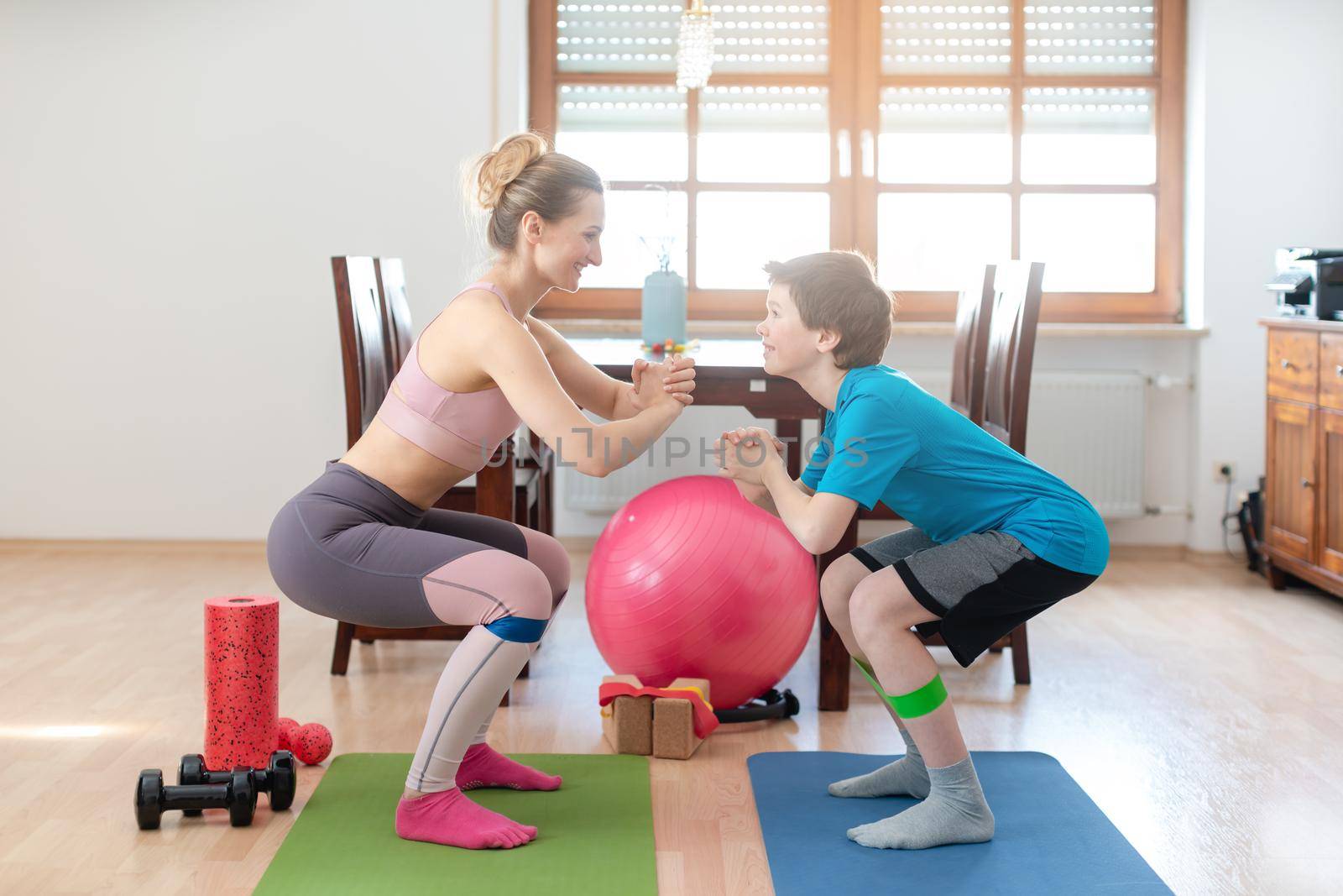 Family doing squats on floor at home during Covid-19 curfew staying fit