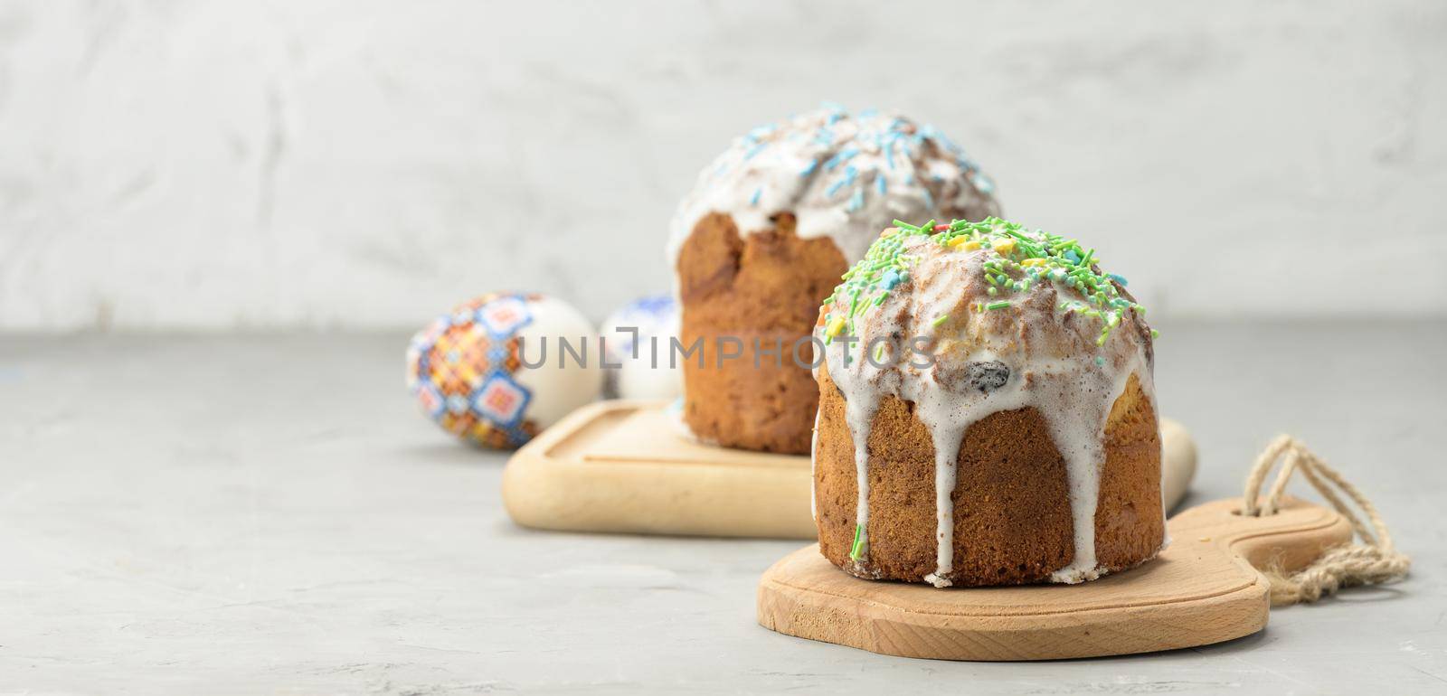 baked traditional Christian dessert for Easter holiday. The pastries are glazed and decorated with multi-colored sprinkles, white backgroundm copy space