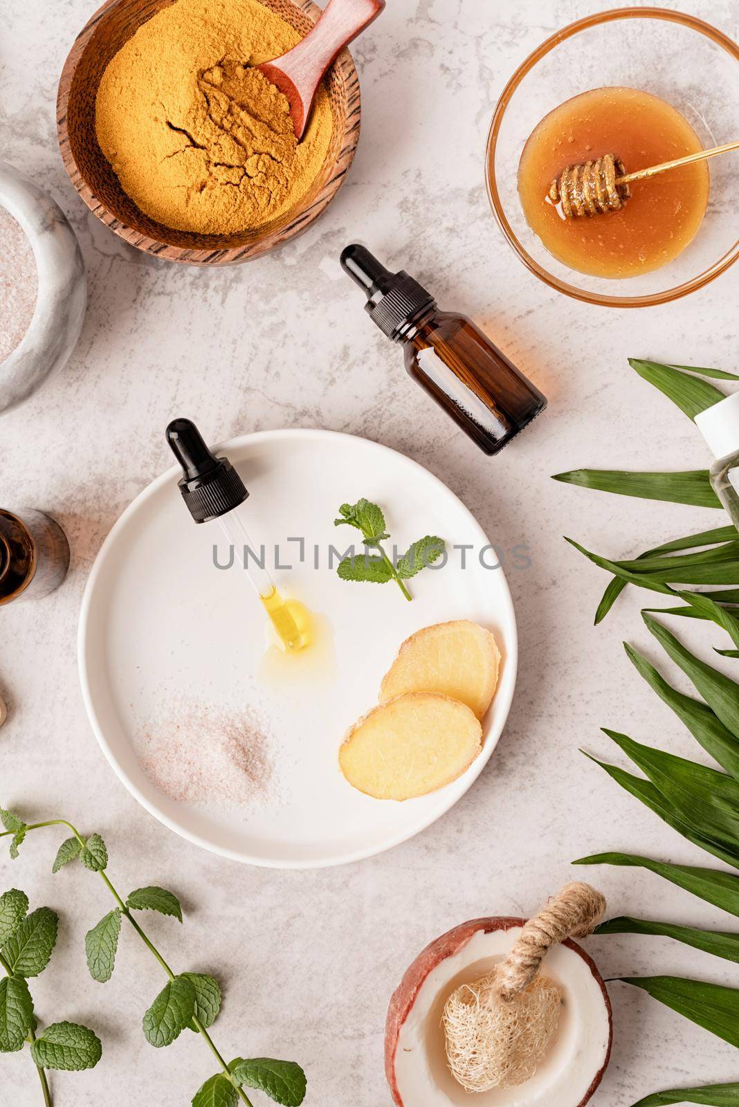 Natural cosmetics ingredients for skincare, body and hair care. Top view bottles with facial treatment product, tropical leaves