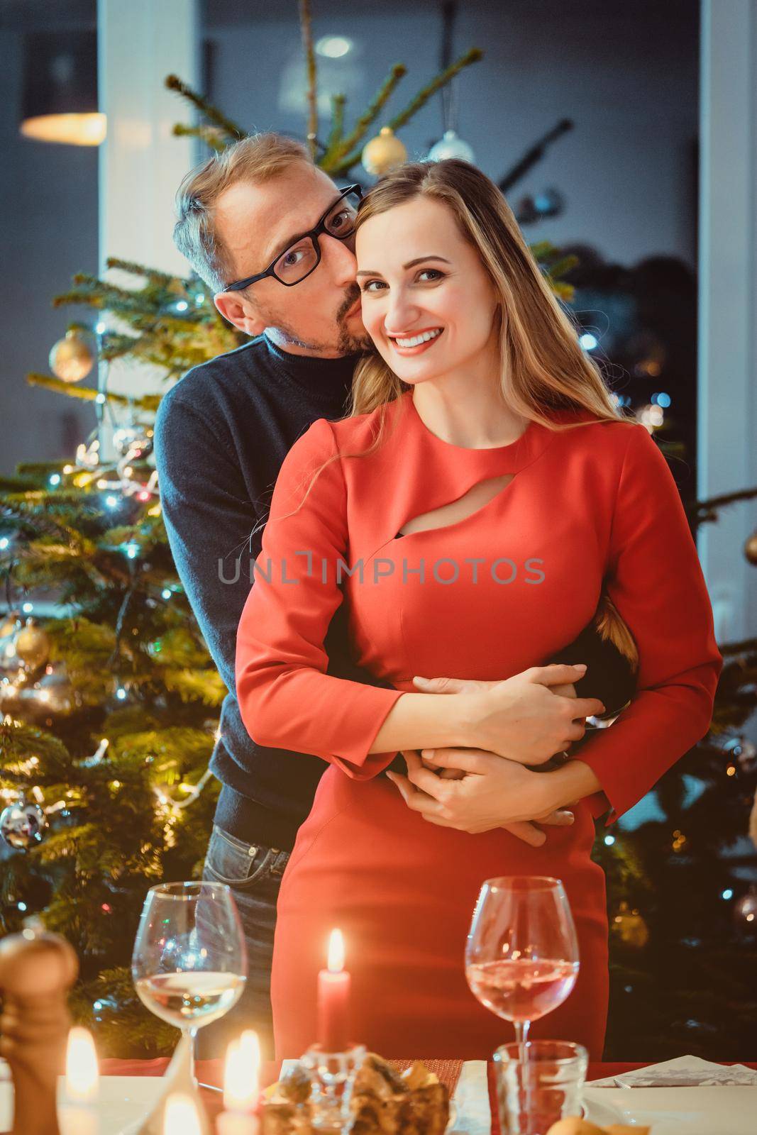 Middle aged couple in romantic pose in front of Christmas tree in seasonal spirit