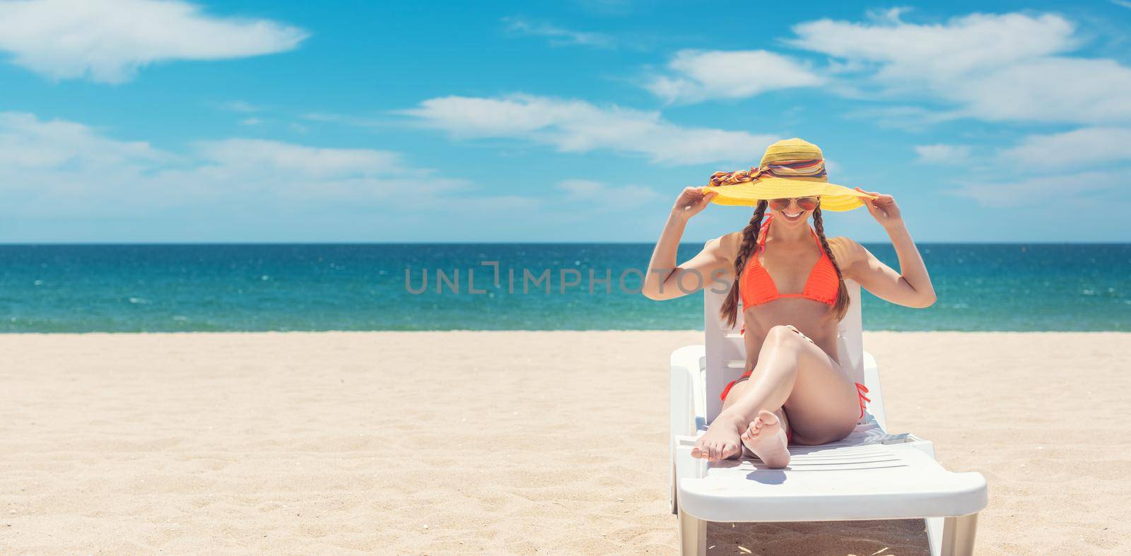 Banner of woman tanning on the beach by the sea in her vacation holding her hat