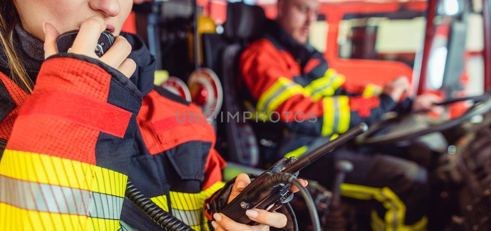 Fire fighter woman on duty using the radio by Kzenon