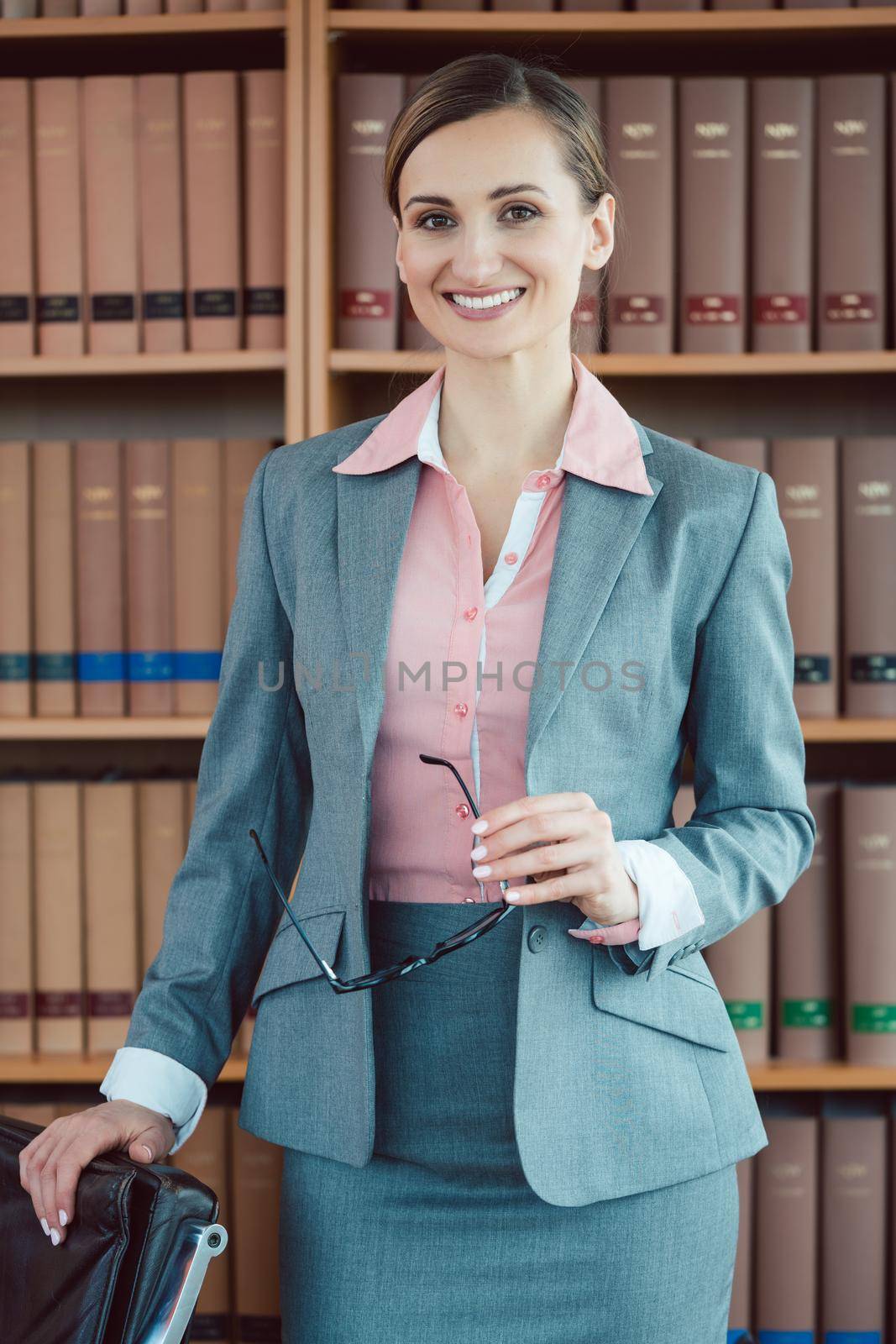 Attorney at law in her office in front of book shelf by Kzenon