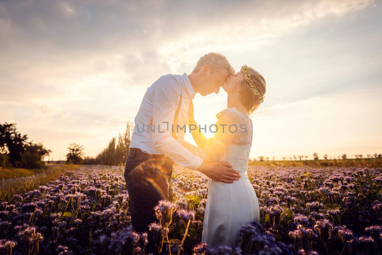 Romantic wedding in the countryside, bride kissing the groom by Kzenon