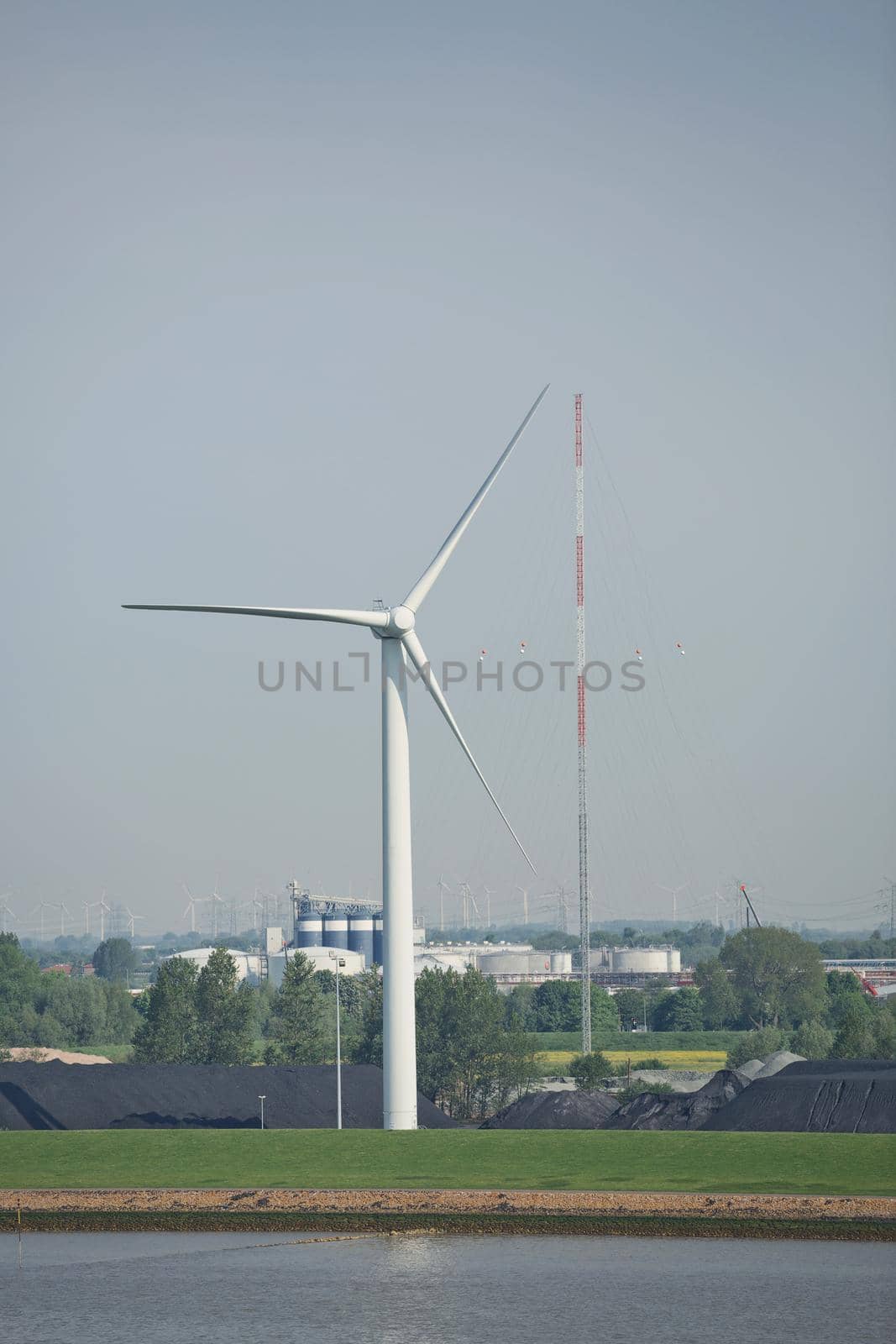 Windmills power plant and turbines generating renewable green energy near to Kiel canal in Germany by wondry