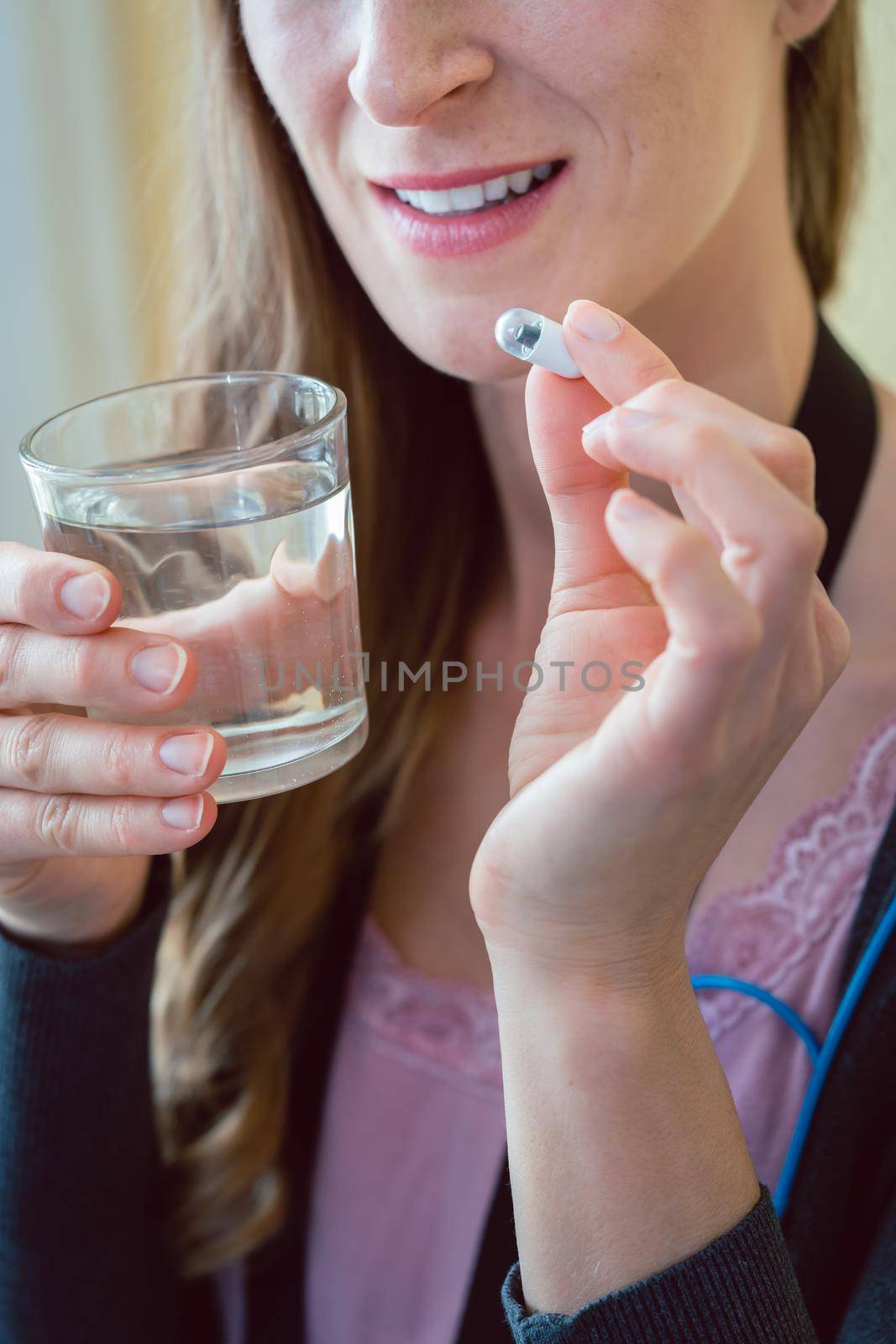 Woman patient swallowing capsule endoscopy video pill with water