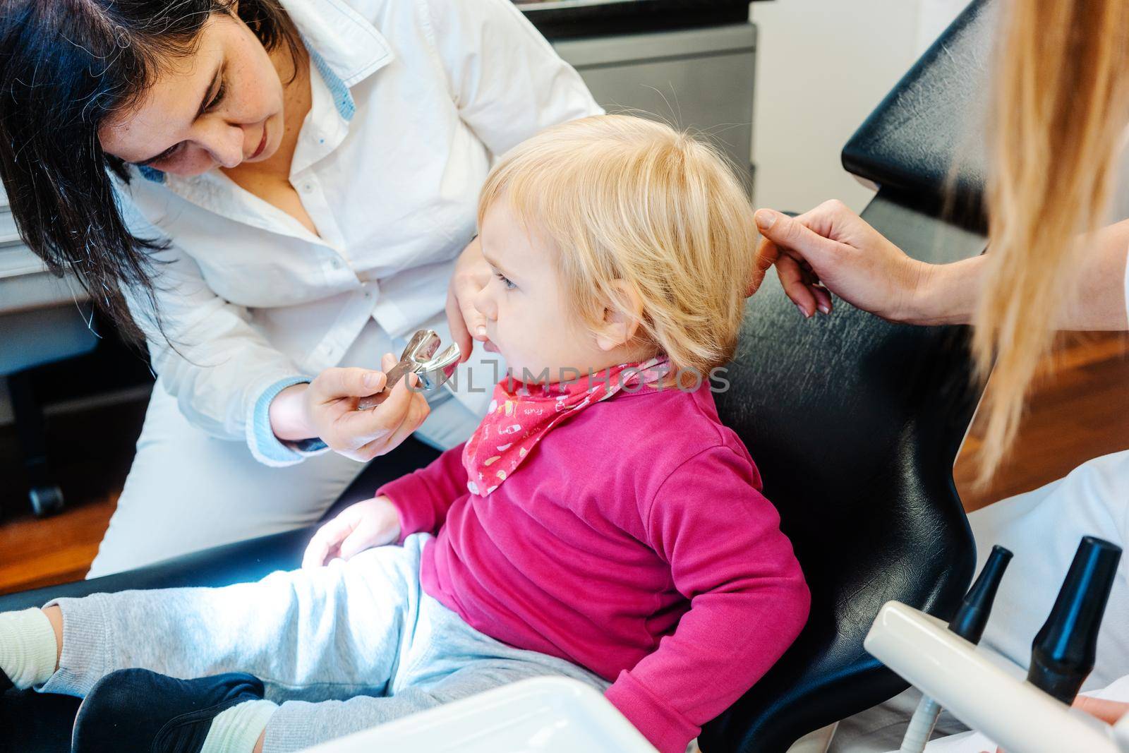 Friendly dentist checking teeth of a little child