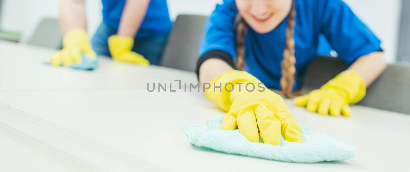 Close-up of cleaning team working in an office, banner cut