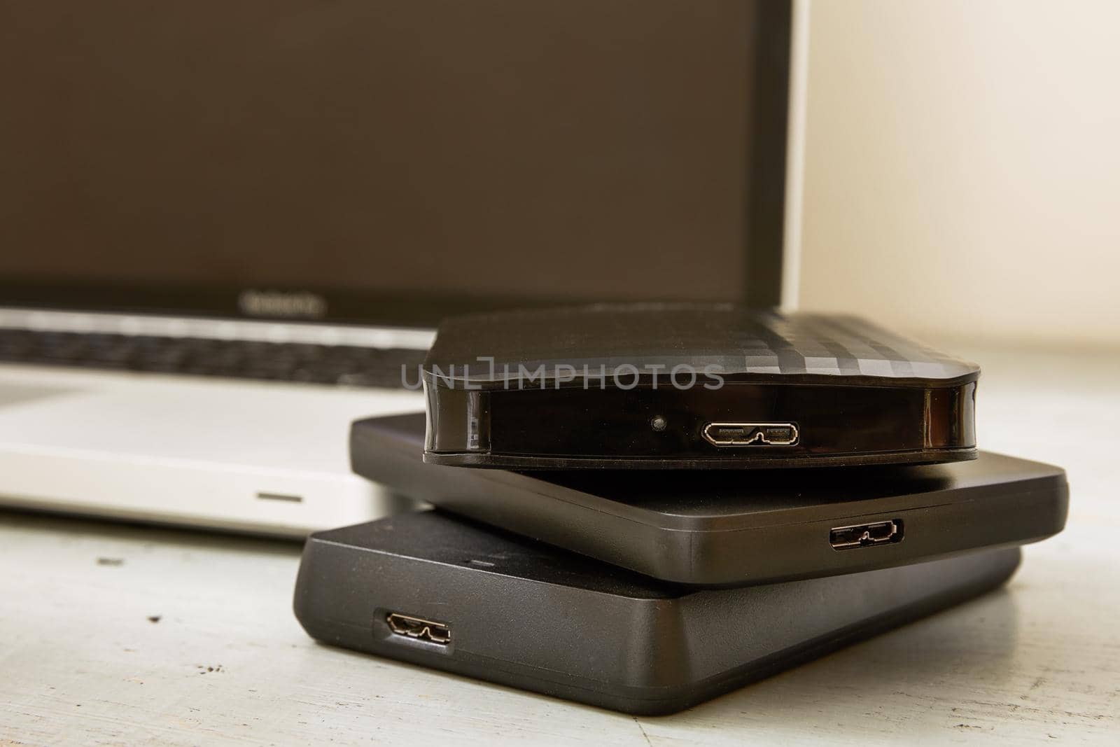 External Hard Disks and Laptop Keyboard on Wooden Table.
