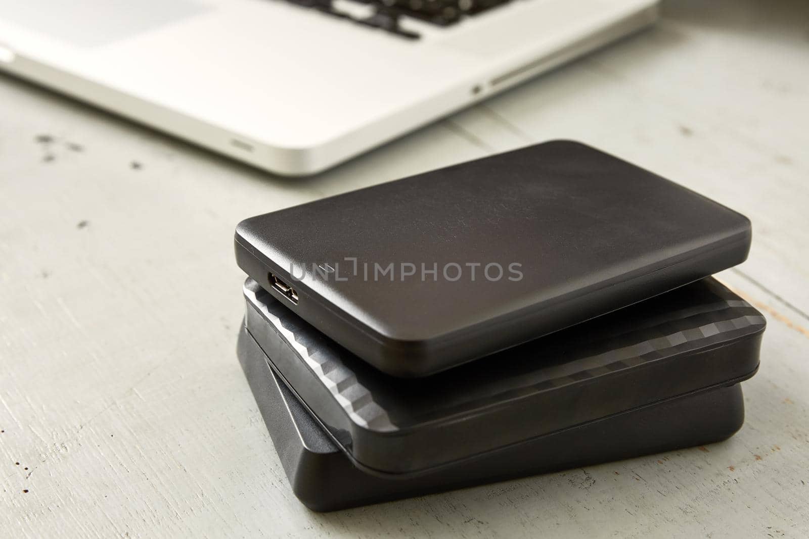 External Hard Disks and Laptop Keyboard on Wooden Table.