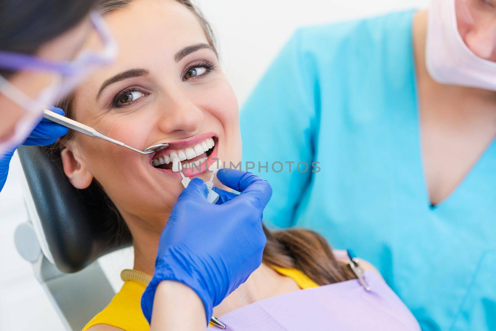 Woman discussing dental bleaching with her dentist by Kzenon