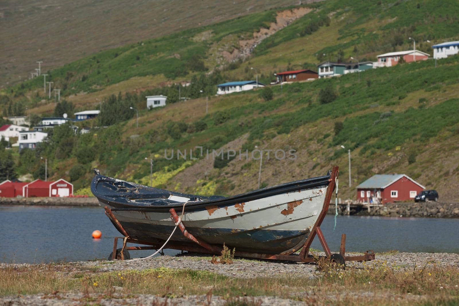 Old vintage boat with a small town of Eskifjodur located in east Iceland in the background.