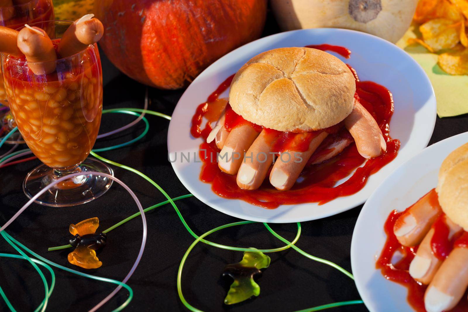 Hot dog in shape of human hand kept in burger with sausage as blood for halloween