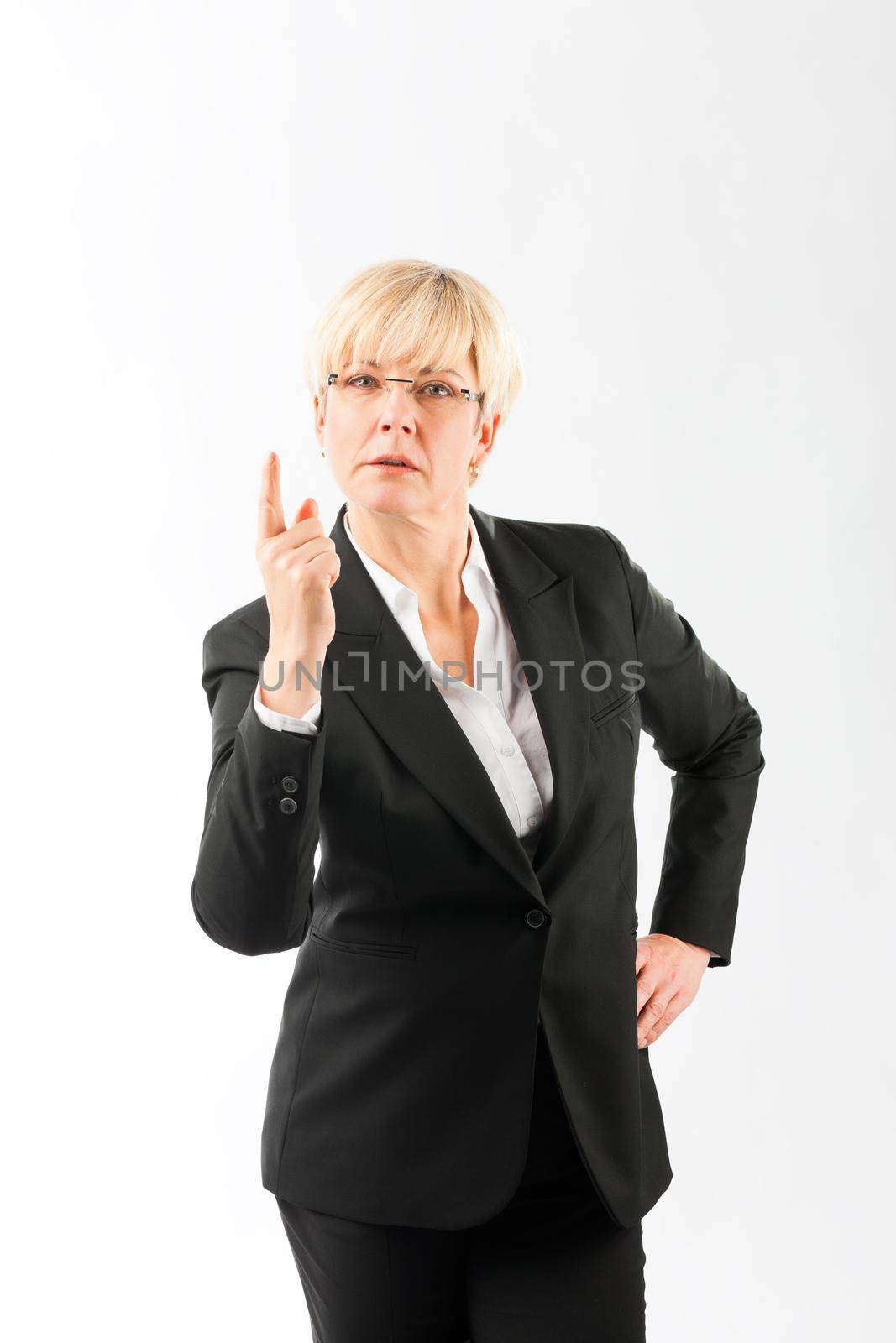 Portrait of serious mature businesswoman pointing finger upward, isolated over white background