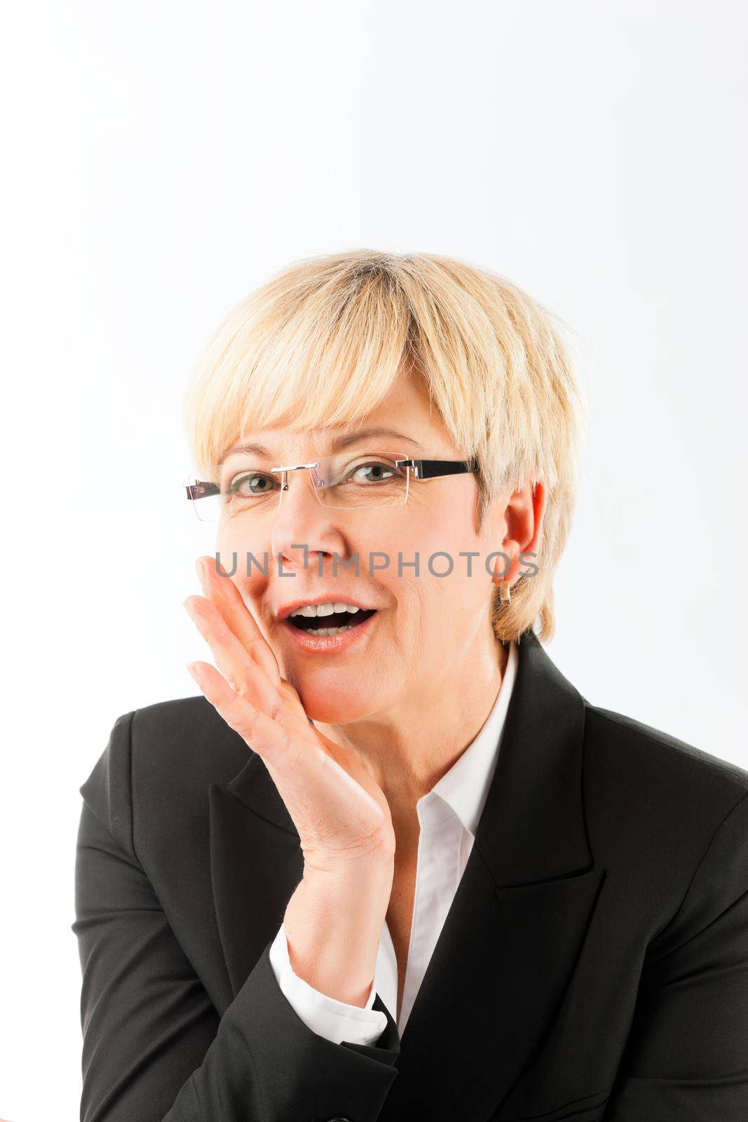 Happy blonde mature businesswoman saying secret against white background