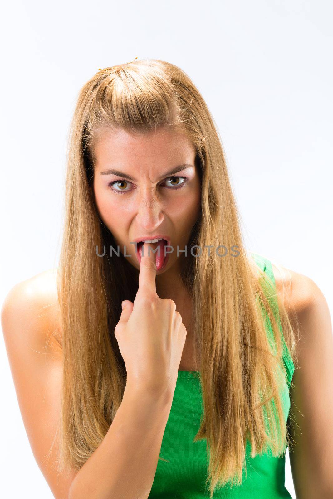 Portrait of young woman with finger on her tongue against white background