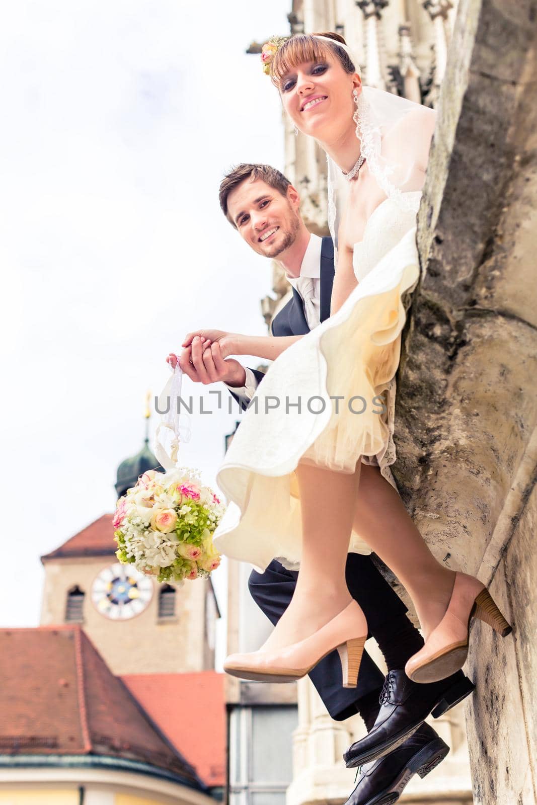 Smiling young married couple holding flower bouquet at outdoors