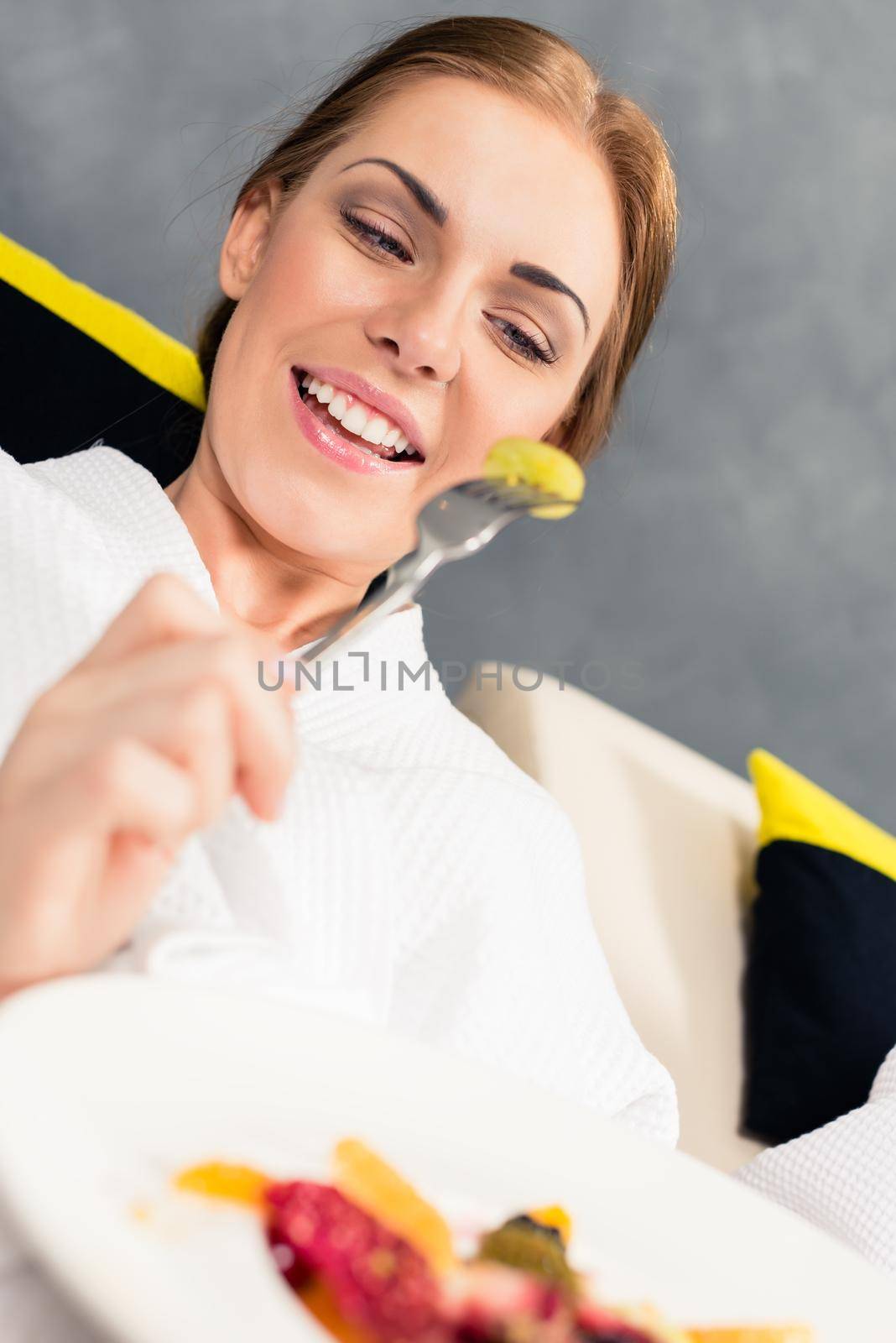 Smiling woman eating healthy food by Kzenon