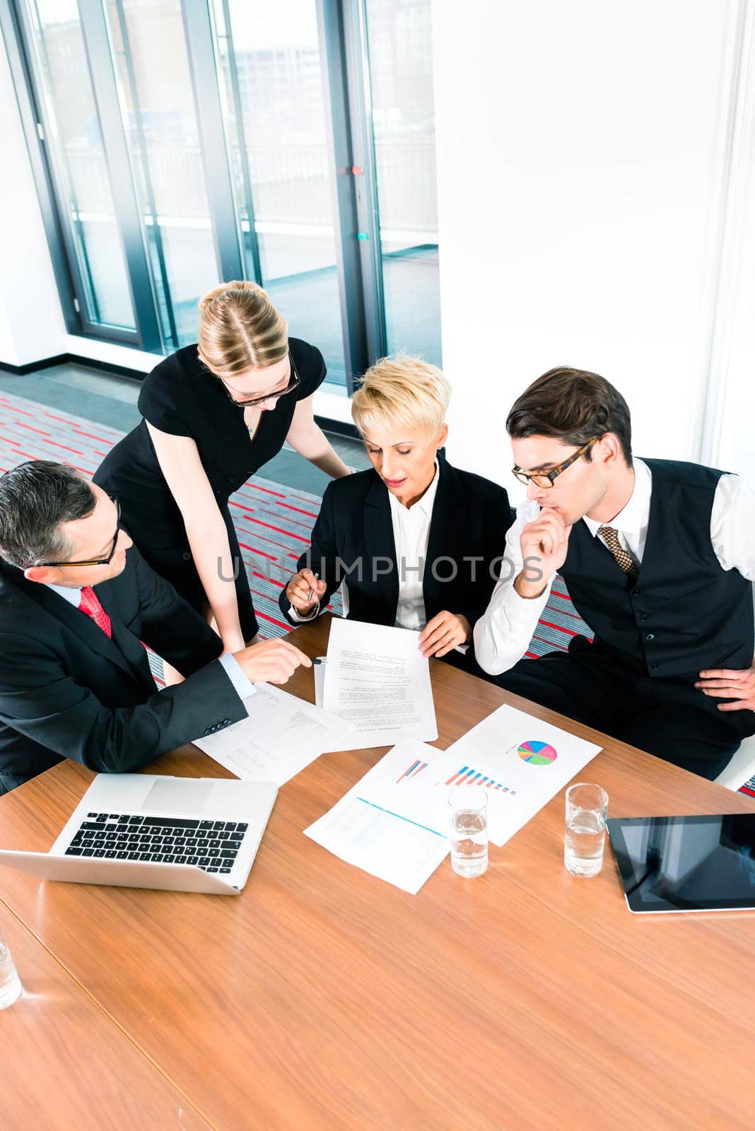 Elevated view of business people studying financial data in meeting