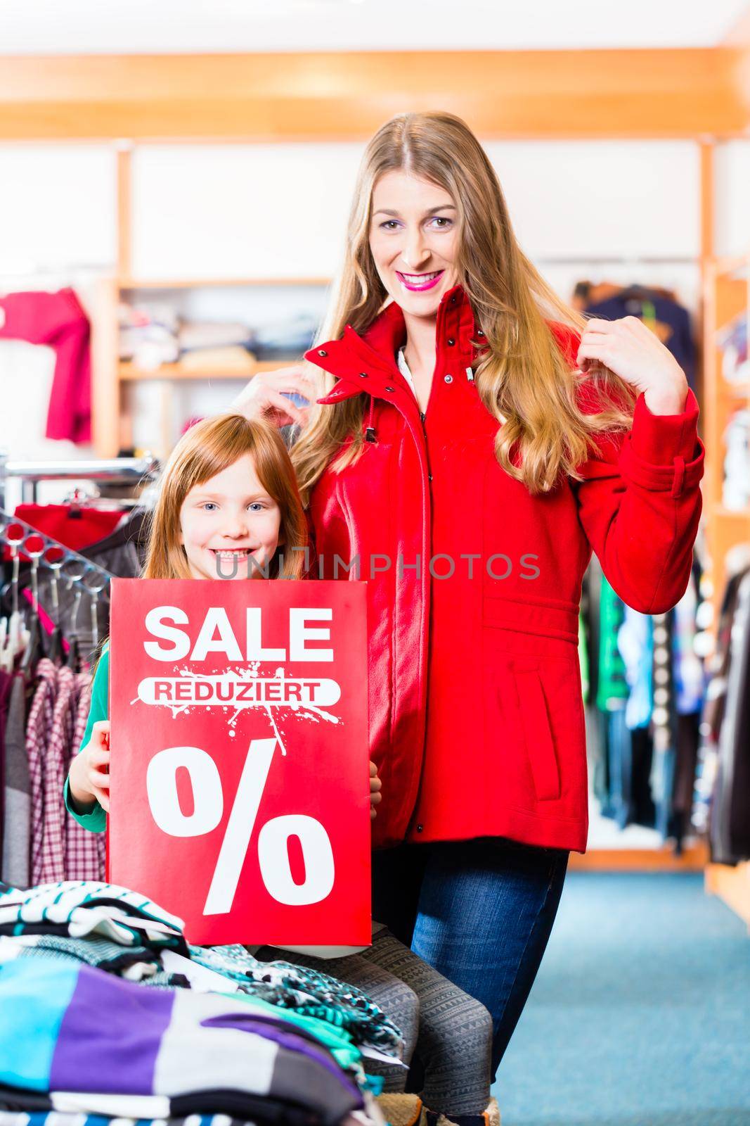 Smiling little girl and woman promoting sale offer by Kzenon