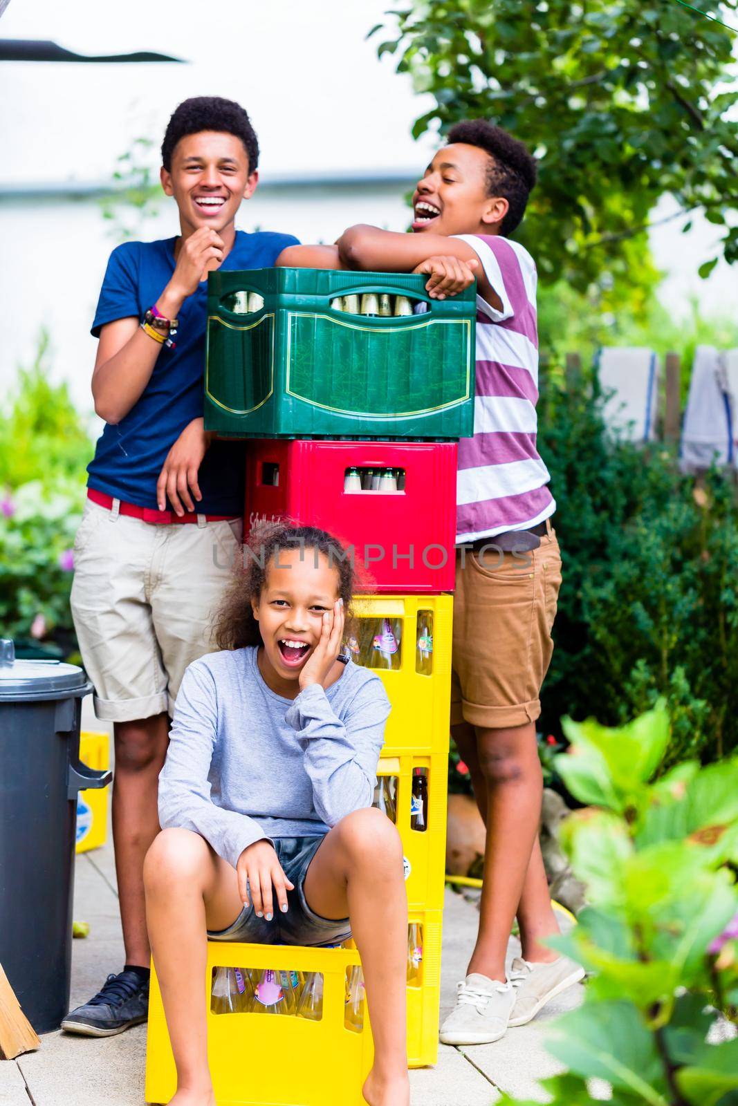 Portrait of happy kids near the colorful bottles crate in the park