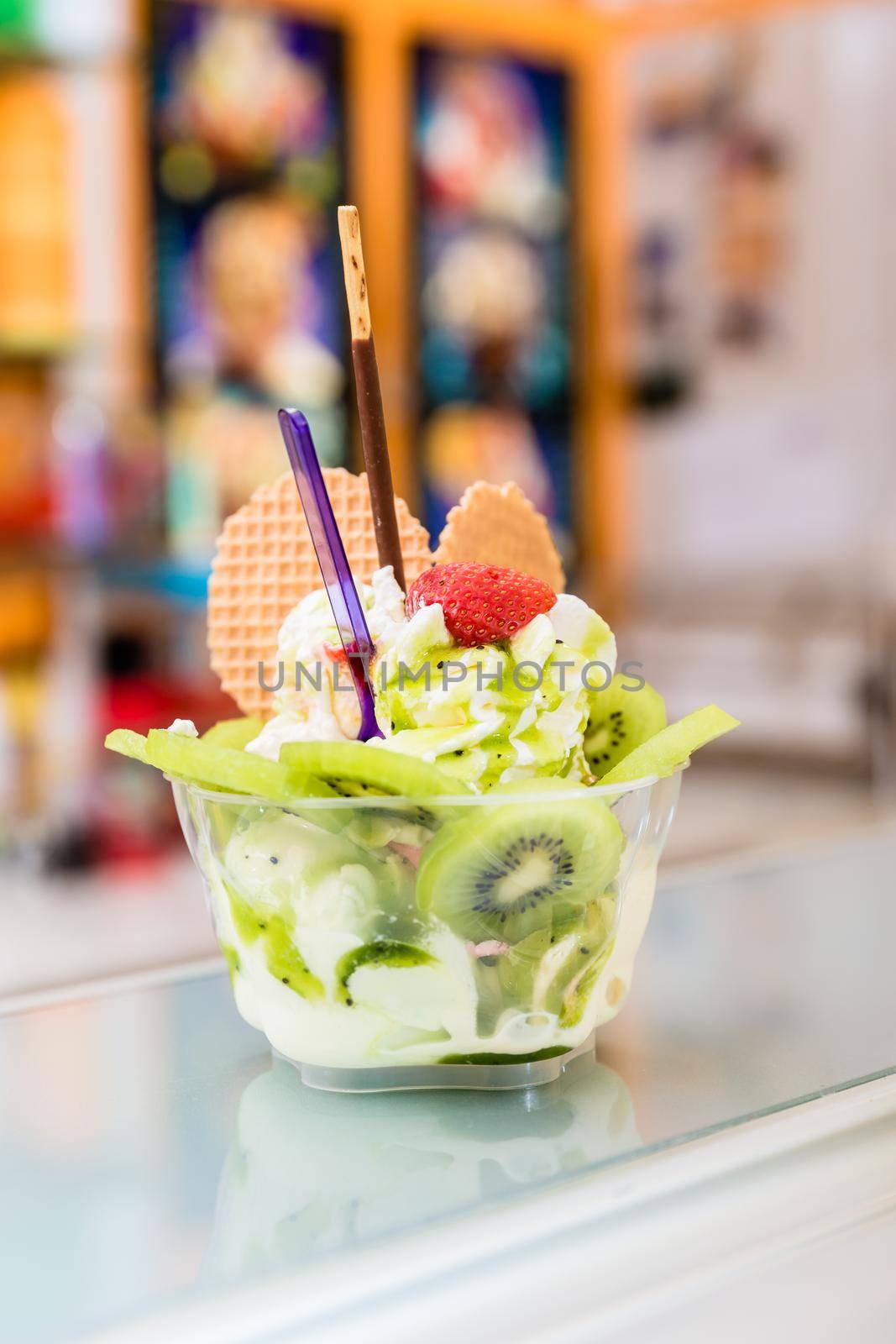 Sundae made of vanilla ice and kiwi fruit on the counter of parlor