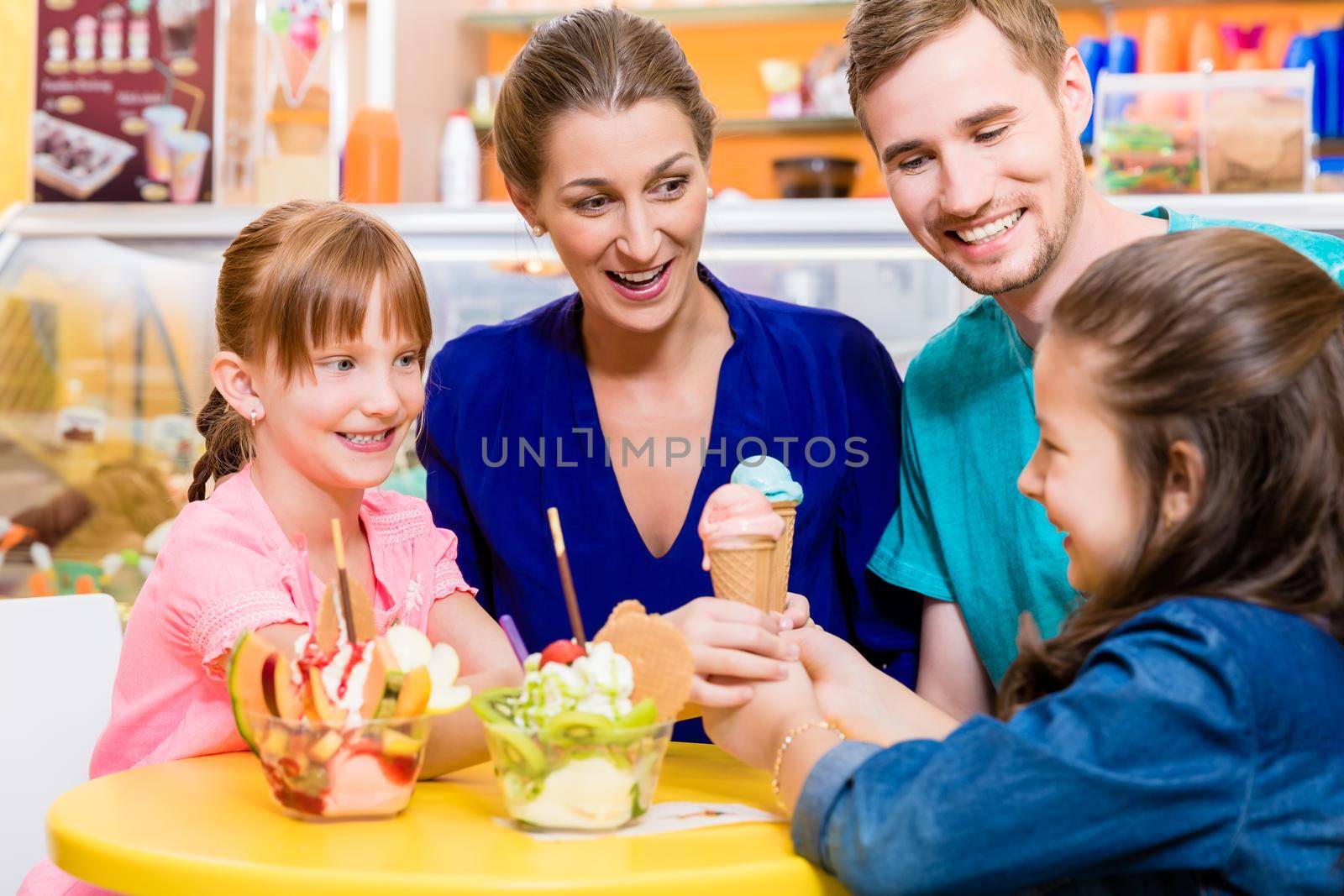 Family in ice cream parlor enjoying a sweet dessert