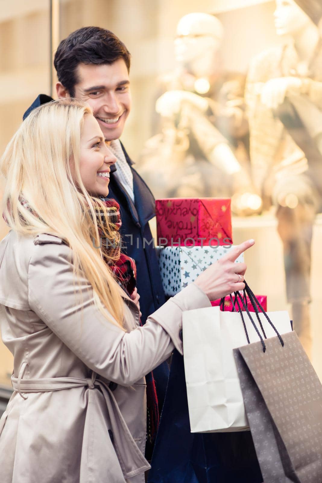 Woman and man with Christmas presents in city by Kzenon