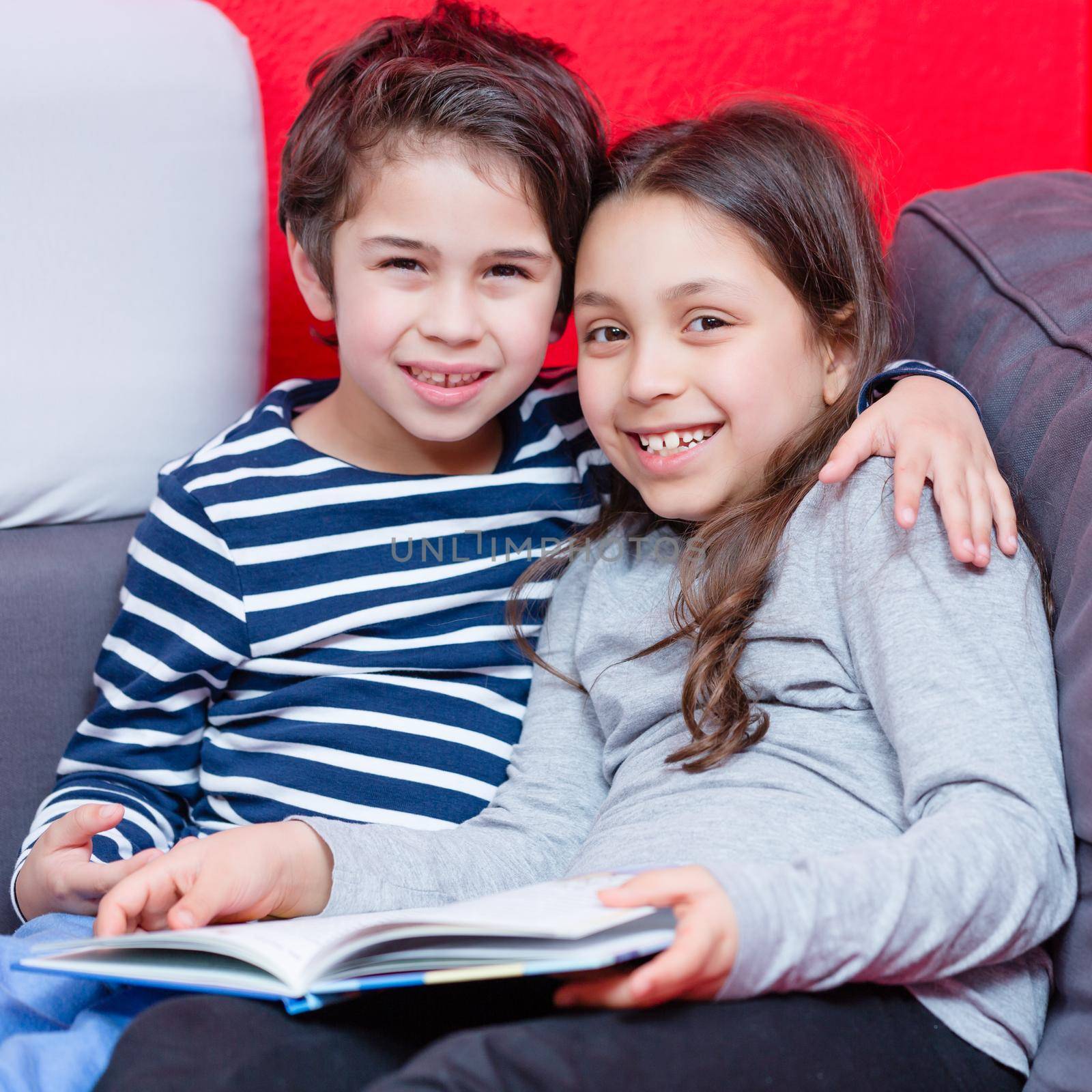 Portrait of smiling brother and sister holding story book