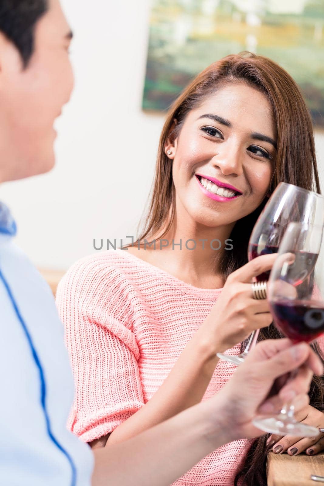 Portrait of smiling woman toasting wine glasses with her boyfriend