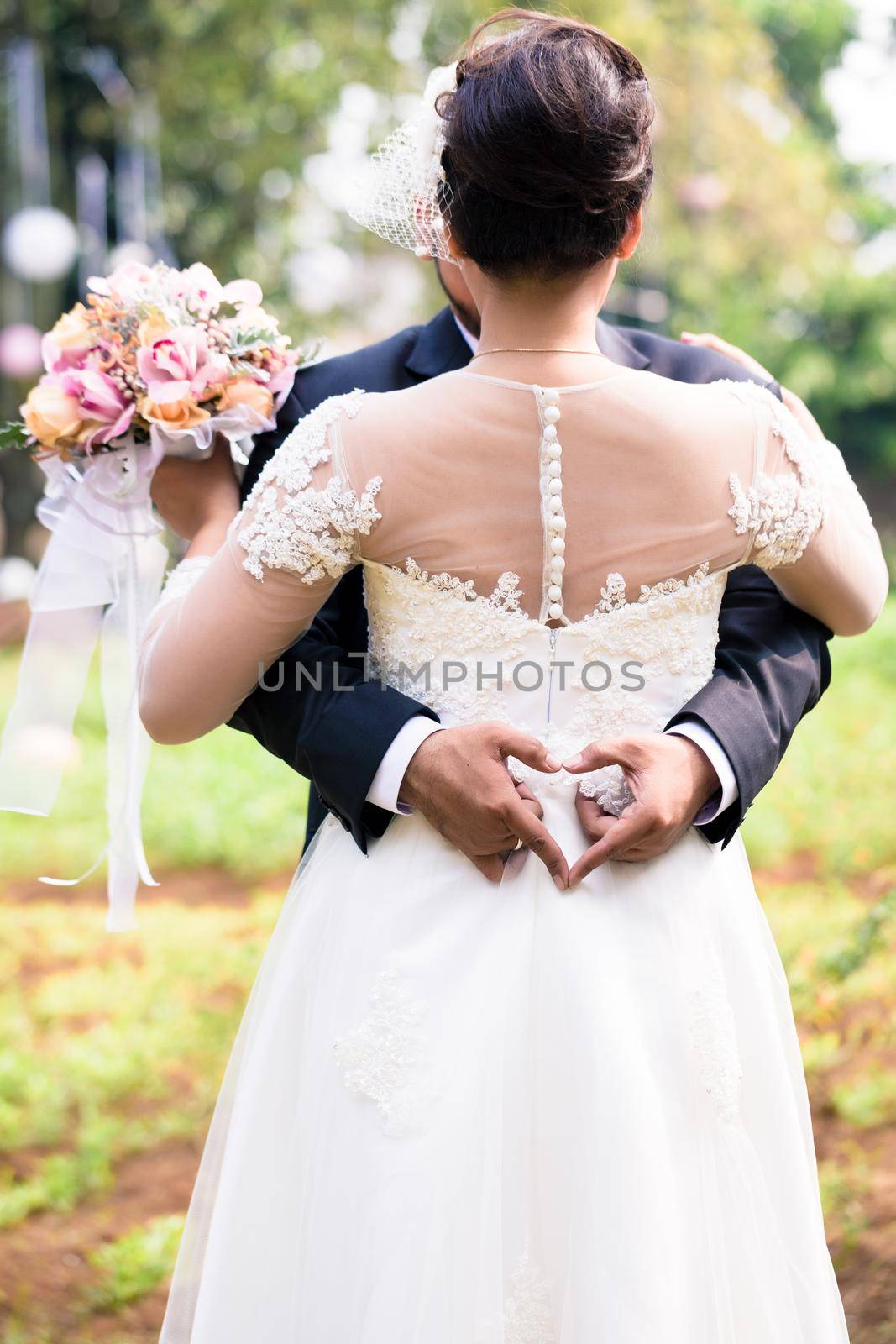 Bride and Bridegroom hugging each other at wedding by Kzenon