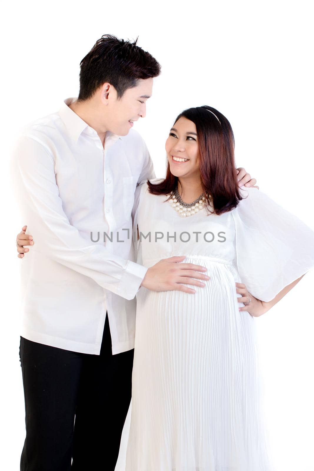 Husband touching her pregnant wife's belly isolated over white background
