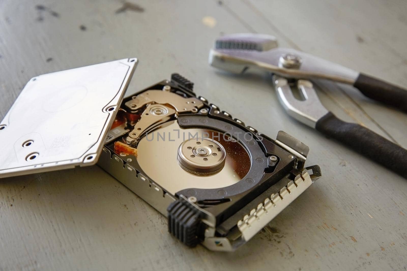 Broken and Destroyed Hard Drive Disk on Wooden Table.