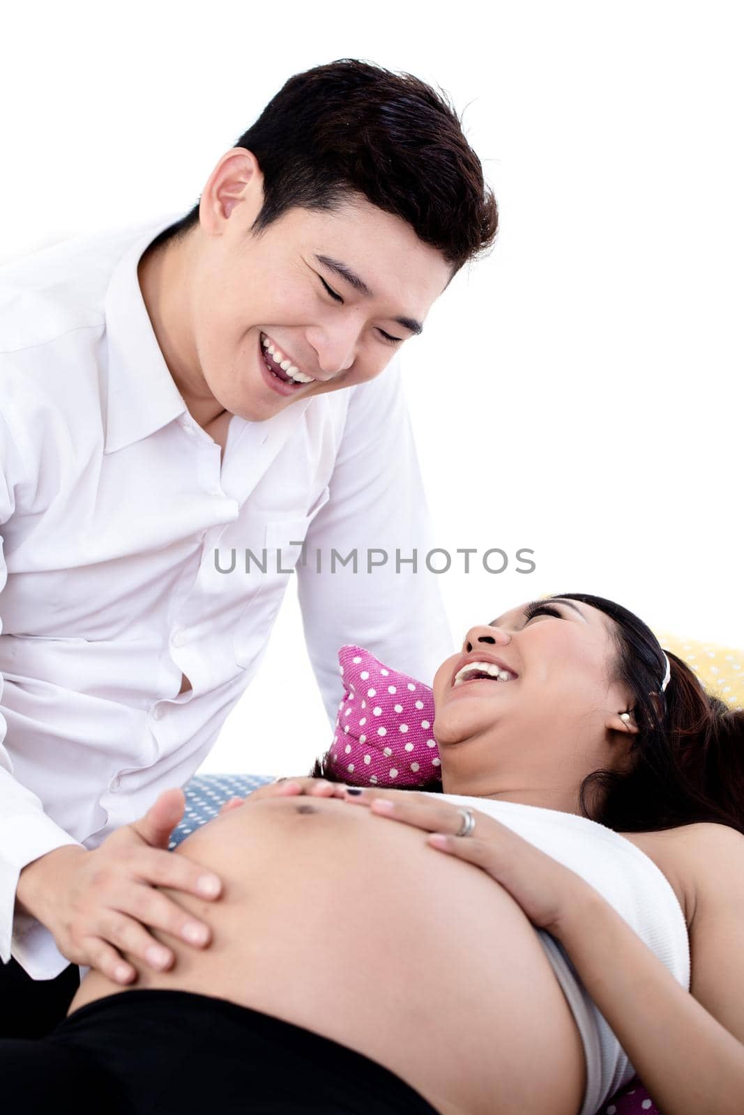 Smiling husband taking care of his pregnant wife by Kzenon