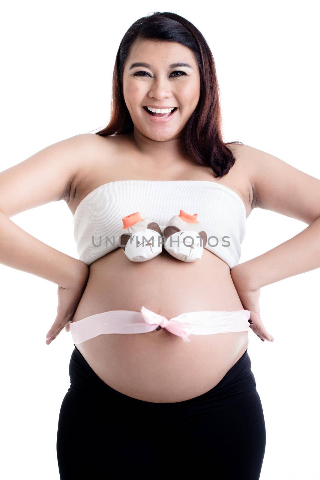 Pregnant woman's belly with baby shoes and ribbon bow by Kzenon
