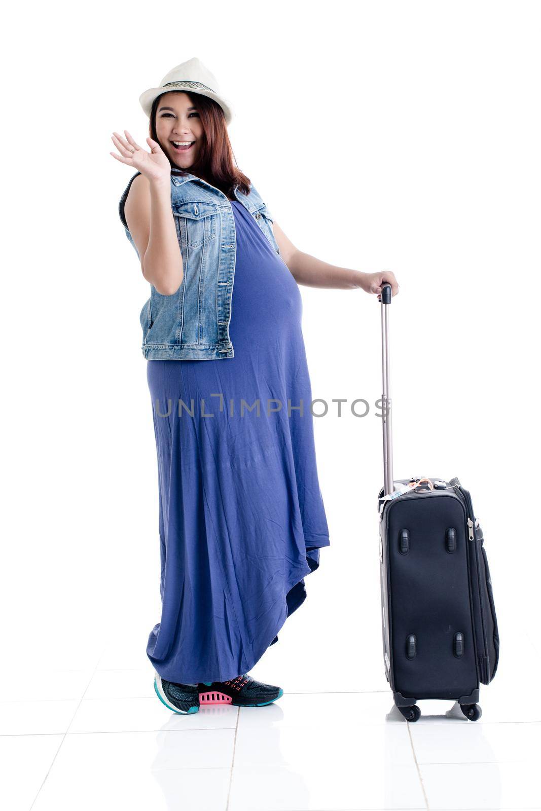 Pregnant woman going for holidays with luggage bag by Kzenon