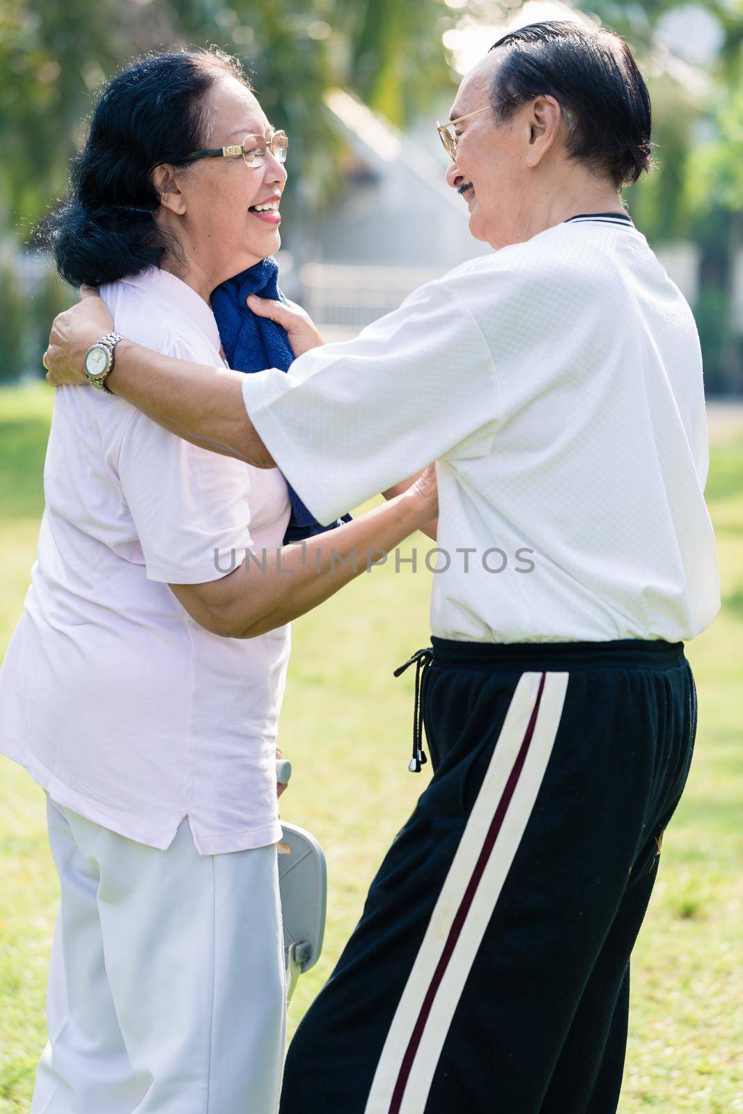 An elderly man wipe the sweat from his wife's face with towel by Kzenon